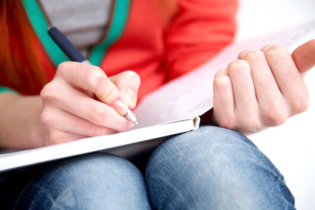 female hands writing in journal