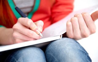 female hands writing in journal